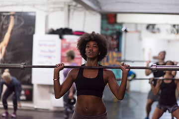 Image showing black woman lifting empty bar