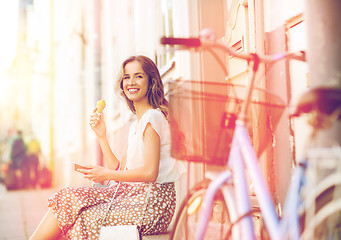 Image showing happy woman with smartphone, bike and ice cream