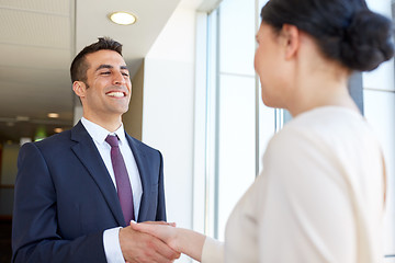 Image showing smiling business people shaking hands at office