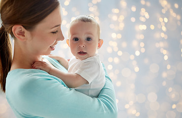 Image showing happy young mother with little baby over lights