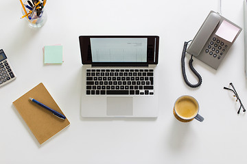 Image showing laptop, phone and other office stuff on table