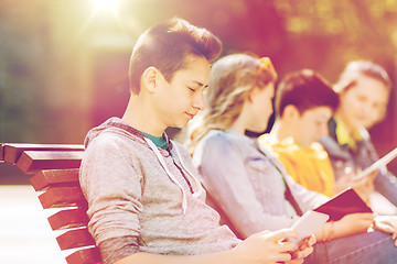 Image showing happy teenage boy with tablet pc computer outdoors