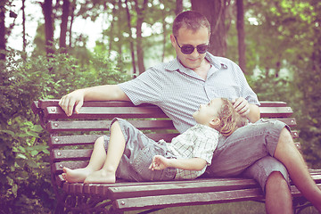 Image showing Father and son playing at the park on bench at the day time.