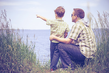 Image showing Father and son playing at the park near lake at the day time.