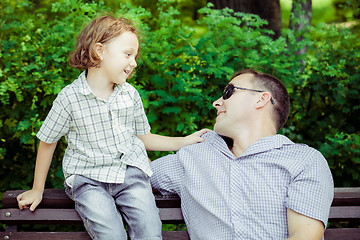 Image showing Father and son playing at the park on bench at the day time.