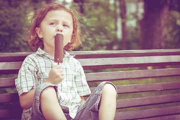 Image showing little boy eating ice cream in the park