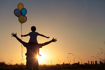 Image showing Father and son playing at the park at the sunset time.