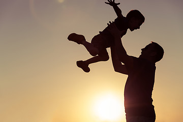 Image showing Father and son playing in the park at the sunset time.