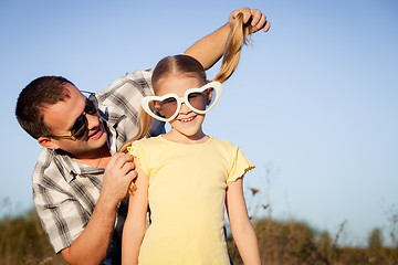 Image showing Dad and daughter in sunglasses playing near a house at the day t