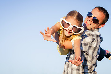 Image showing Dad and daughter in sunglasses playing near a house at the day t