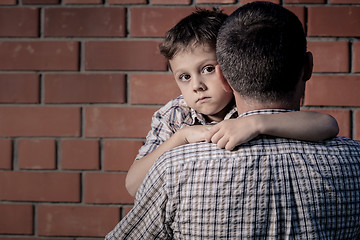 Image showing Portrait of sad son hugging his dad