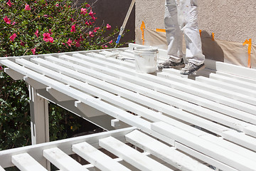 Image showing Professional Painter Rolling White Paint Onto The Top of A Home 