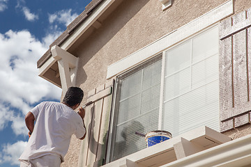 Image showing Professional House Painter Painting the Trim And Shutters of A H