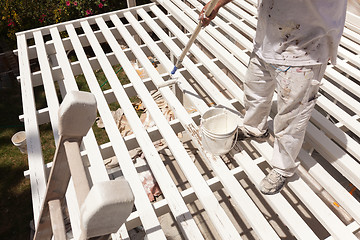 Image showing Professional Painter Rolling White Paint Onto The Top of A Home 