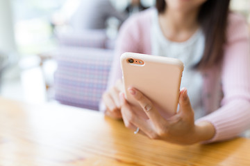 Image showing Woman sending sms on cellphone