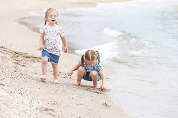 Image showing Children on the sea beach. Twins going along sea water.