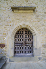 Image showing Stone wall with barred wooden door