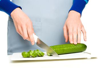 Image showing Cook is chopping green cucumber