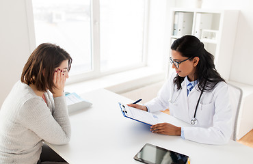 Image showing doctor with clipboard and woman patient at clinic