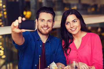 Image showing couple taking selfie by smartphone at restaurant