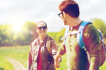 Image showing happy couple with backpacks hiking outdoors