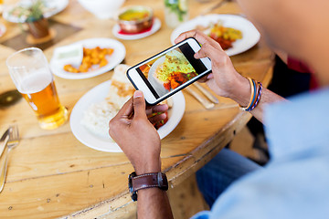 Image showing hands with smartphone picturing food at restaurant