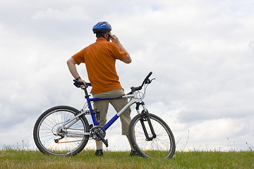 Image showing Man with mountain bike talking on cell phone