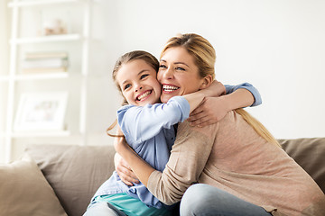 Image showing happy smiling family hugging on sofa at home