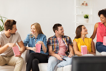 Image showing happy friends with popcorn and tv remote at home