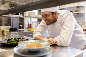 Image showing happy male chef cooking food at restaurant kitchen