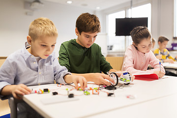 Image showing happy children building robots at robotics school