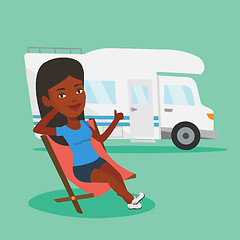 Image showing Woman sitting in chair in front of camper van.