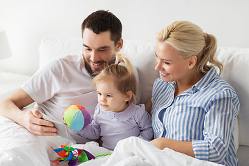 Image showing happy family with smartphone in bed at home