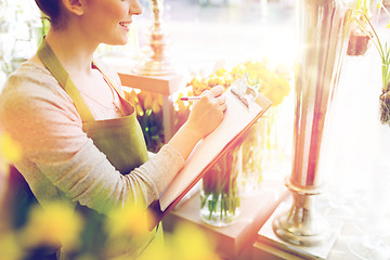 Image showing close up of woman with clipboard at flower shop