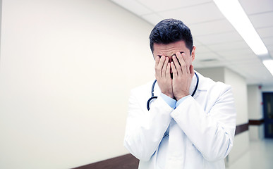 Image showing sad or crying male doctor at hospital corridor