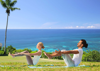 Image showing couple making yoga half-boat pose outdoors