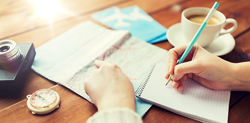 Image showing close up of traveler hands with notepad and pencil