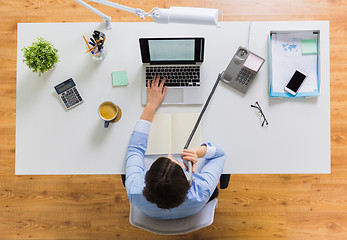 Image showing businesswoman calling on phone at office table