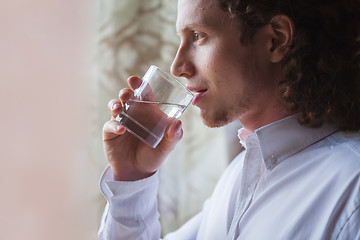 Image showing Man drinking water in studio