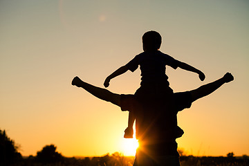 Image showing Father and son playing in the park at the sunset time.