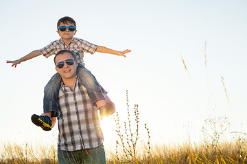 Image showing Father and son playing on the field at the day time.