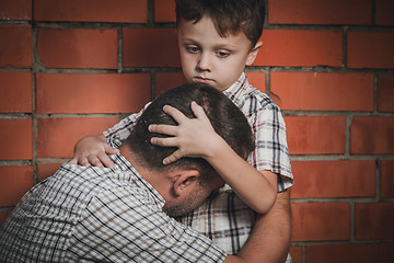 Image showing Portrait of sad son hugging his dad