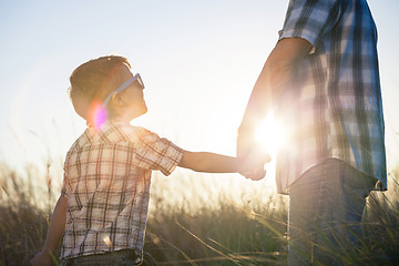 Image showing Father and son playing on the field at the day time.