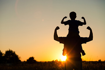 Image showing Father and son playing in the park at the sunset time.