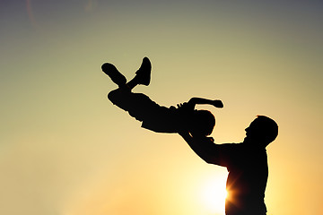 Image showing Father and son playing in the park at the sunset time.