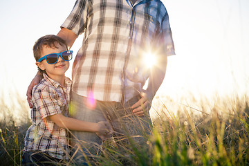 Image showing Father and son playing on the field at the day time.