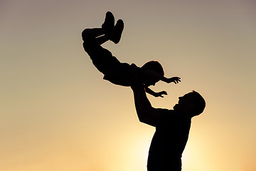 Image showing Father and son playing in the park at the sunset time.