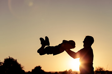 Image showing Father and son playing in the park at the sunset time.