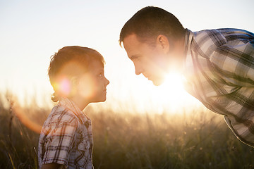 Image showing Father and son playing on the field at the day time.