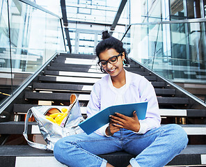 Image showing young cute indian girl at university building sitting on stairs 